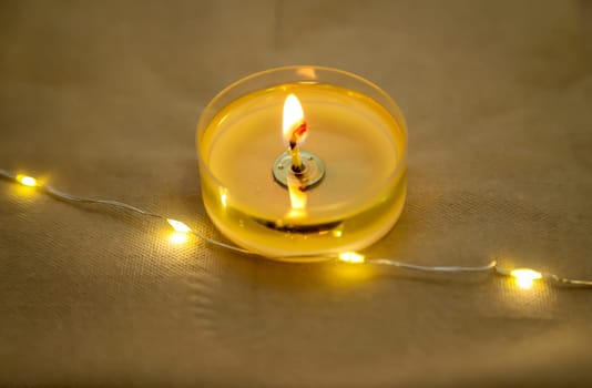 A burning tea light as a table decoration on a festively set table.