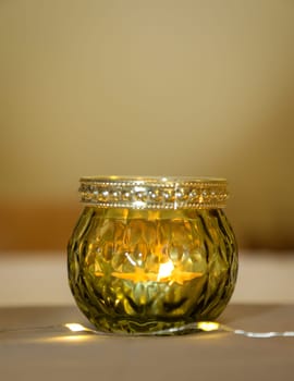 A lantern with a tea light atmospherically illuminates a table in the evening.