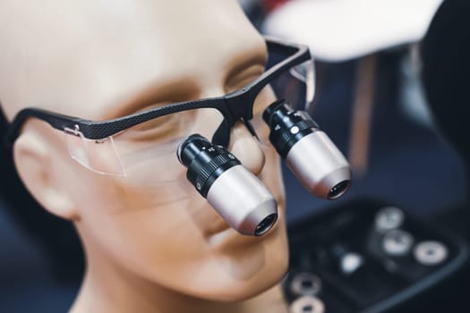 closeup of dental microscope protection glasses with black frame on display on a medical model