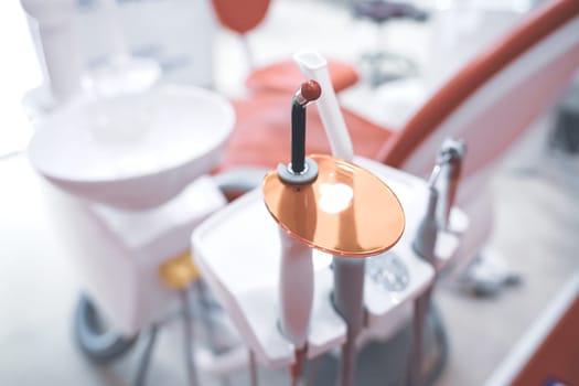 closeup perspective view of dental filling polymerization ultraviolet lamp near chair in dentist office