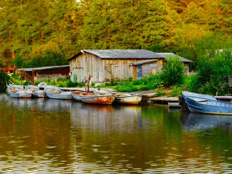 fishing boats moored dy old barn tilt shift rural landscape