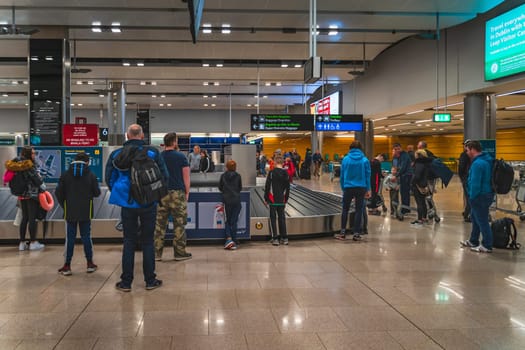 Dublin, Ireland, Feb 2020 People, families waiting at belt conveyor to collect luggage after arrival to Dublin airport