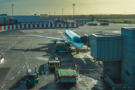 Dublin, Ireland, Feb 2020 Aer Lingus Boeing airplane parked in a bay on Dublin Airport. Service crew and equipment in operation on airport runway