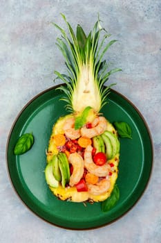 Half a pineapple with vegetables, rice and seafood.Shrimps salad in a pineapple. Asiatic cuisine