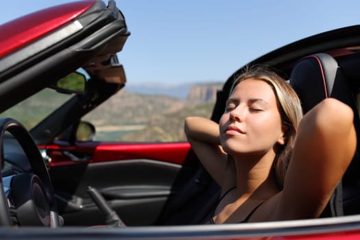 Convertible car driver resting a sunny day in the mountain
