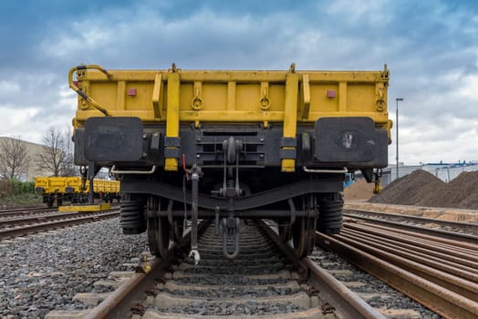 Rear view of a yellow open freight wagon.