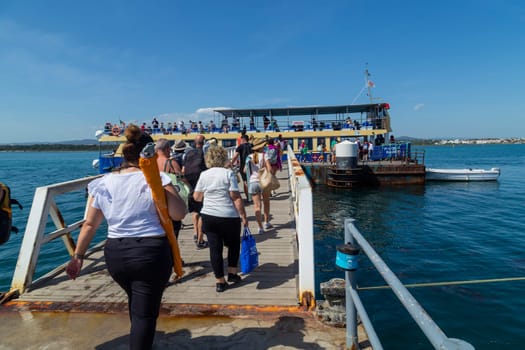 Olhao, Portugal: April 14th, 2022 - People walking along the pier of Armona Island, in Portugal, after the trip navigating Ria Formosa from Olhao city