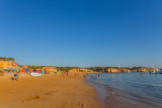 Ferragudo, Portugal - 25 August 2025: Beautiful seascape with beach, cave and ocean. Praia Grande beach. Ferragudo, Lagoa, Algarve, Portugal