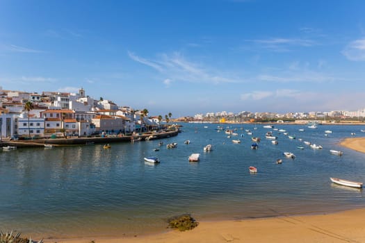 Ferragudo, Portugal - August 25, 2022 - View of the white town with boats moored in the foreground, Ferragudo, Algarve, Portugal, Europe