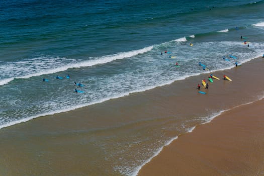 Sagres, Portugal - August 25, 2022: View of surfers on sandy beach near Sagres village in Algarve, Portugal