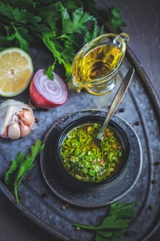 Chimichurri verde - traditional Argentine condiment, made from finely chopped parsley, minced garlic, olive oil, oregano, and wine vinegar