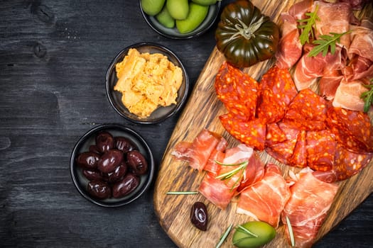Charcuterie board with prosciutto ham, salami, olives and tapas