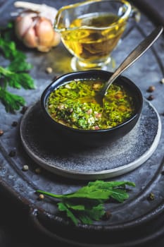 Chimichurri verde - traditional Argentine condiment, made from finely chopped parsley, minced garlic, olive oil, oregano, and wine vinegar