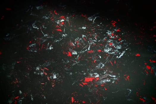 Black background with red, white, gray and blue strokes, dashes, stains and scuffs. A ray of light