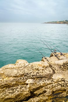 Fishing rods on the rocks of the coast of Cascais, Portugal