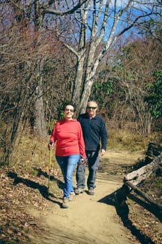 Senior couple is hiking in the woods in North Carolina in fall