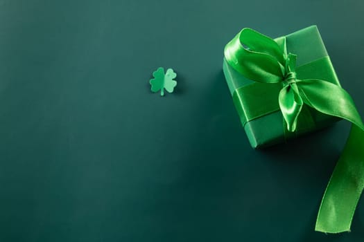 Happy St Patrick's Day decoration background concept. Top view gift box green clover leaves, shamrocks leaves holiday symbol with copy space on green background