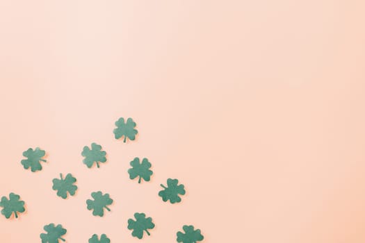 Happy St. Patrick's Day decoration background. Flat lay of cutting paper clover leaves festive decor, shamrocks leaves holiday symbol with copy space on colour background, Banner greeting card concept