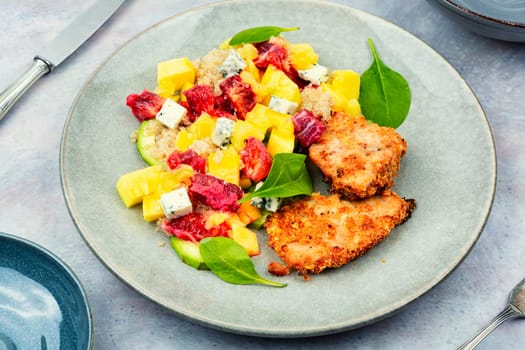 Appetizing salad with chicken meat, orange, mango and quinoa