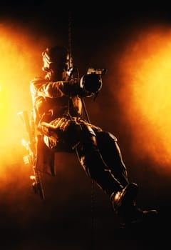 Silhouette of police officer in tactical gear descending from a height, rope exercises with weapons. Tactical rappelling, anti-terror or counter terrorism operation in darkness in rappelling harness