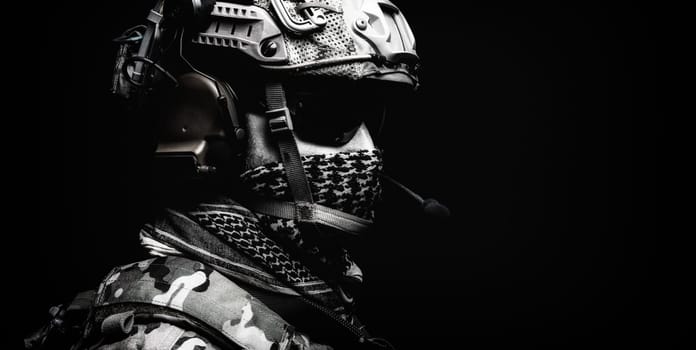 Modern army special forces equipped soldier, anti terrorist squad fighter, elite mercenary in helmet, studio portrait in darkness. Close up, half length