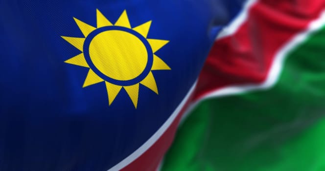 Close-up view of the Namibia national flag waving. Blue stripes, yellow sun, red, white stripes, green. Ovambo color. 3d illustration render. Selective focus. Close-up. Textured fabric background