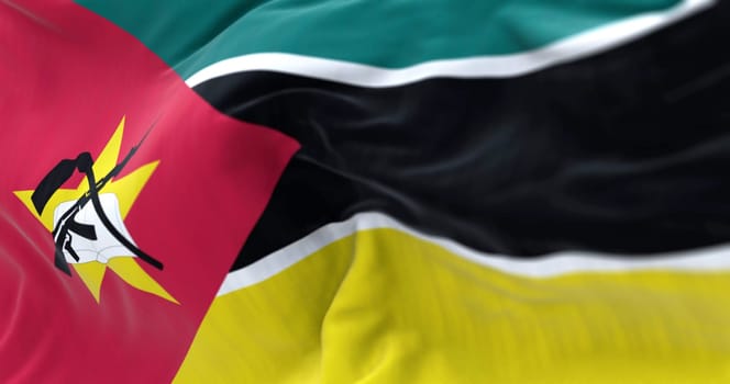 Detail of the Mozambique flag waving. green, black, and yellow stripes, red triangle, yellow star, crossed book, hoe, and AK-47. 3d illustration render. Selective focus. Close-up. Textured background