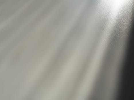 Diagonal rays of light on a gray background. Blurred abstract background light effect and leaks. Side surface illumination. Parallel, divergent and asymmetric lines, stripes of light at an angle