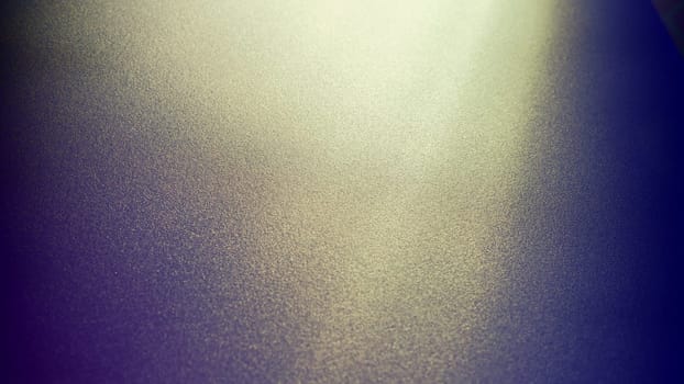 Oblique rays of light on a dark background. Blurred abstract backdrop with light effect and leaks. Side surface illumination. Divergent and asymmetric lines, stripes of light at angle. Yellowish glow.