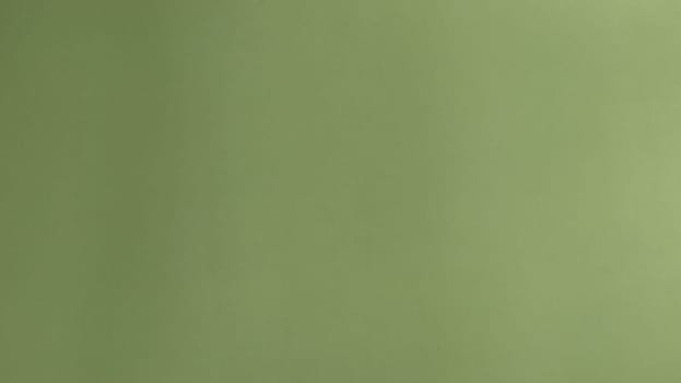 A sheet of light green paper. A calm green hue reminiscent of a grassy tone. Soothing interior color. Gentle gradient from left to right from dark to light