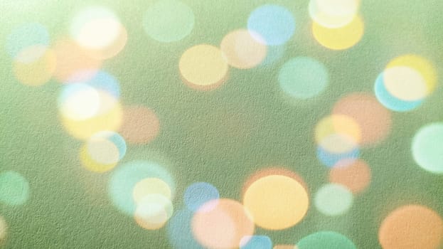 Green background with bokeh effect. A calm green hue reminiscent of a grassy tone. Soothing interior color. Texture of printing paper. Bokeh of different colors - blue, green, pink, yellow and white.