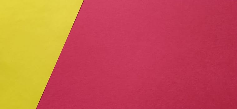 A yellow sheet of paper is laid sideways on a red sheet of paper. Thick paper or thin cardboard. The yellow element is on the left and the red is on the right