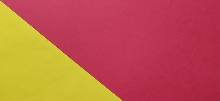 A yellow sheet of paper is laid sideways on a red sheet of paper. Thick paper or thin cardboard. The yellow element is on the left and the red is on the right