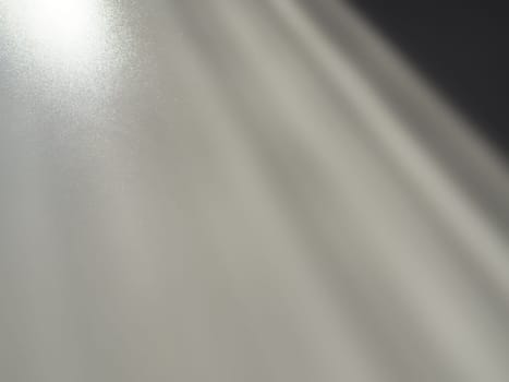 Diagonal rays of light on a gray background. Blurred abstract background light effect and leaks. Side surface illumination. Parallel, divergent and asymmetric lines, stripes of light at an angle.