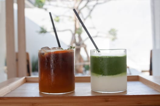 Iced americano with orange and iced matcha green tea in coffee shop, stock photo