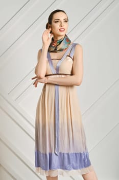 Dreamy young woman with crossed hands and silk scarf on her neck