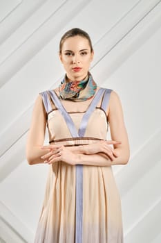 Cute young woman with crossed hands and silk scarf on her neck