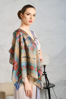 Pretty young woman demonstrating silk shawl thrown on her shoulder