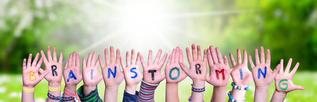 Children Hands Building Colorful English Word Brainstorming. Sunny Green Grass Meadow As Background.