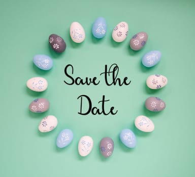 Flat Lay With English Text Save The Date. Easter Egg Arrangement, Decoration And Ornament. Light Green Paper Background