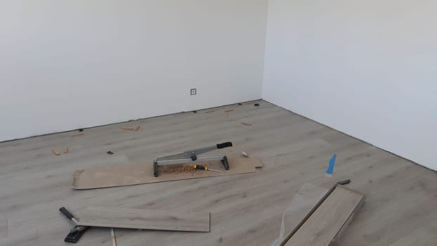 House renovation: DIY installing laminate flooring in a renovated room with white walls