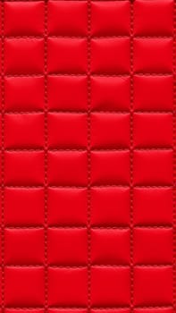 The surface texture of artificial leather in red, stitched in the form of rhombuses, squares, rectangles. Quilted eco-leather. High quality photo