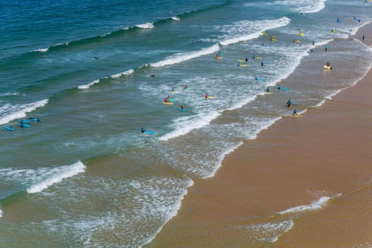 Sagres, Portugal - August 25, 2022: View of surfers on sandy beach near Sagres village in Algarve, Portugal