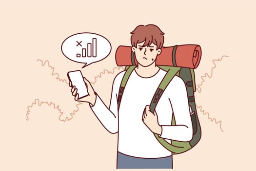 Lost traveler with backpack on back is looking for mobile network to find way home. Guy tourist got lost in forest and was sad when learned about lack of communication or bad GPS signal