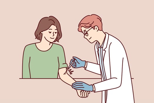 Doctor inoculates girl patient designed to protect against virus and develop immunity. Man clinic employee in white coat puts injection with medical drug into woman hand