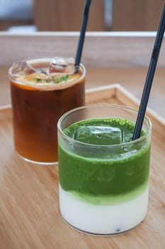 Iced americano with orange and iced matcha green tea in coffee shop, stock photo