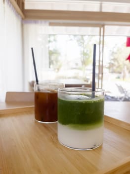 Iced americano with orange and iced matcha green tea in coffee shop, stock photo