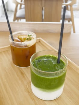 Iced americano with orange and iced matcha green tea in coffee shop, stock photo