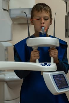 Jaw computed tomography, check up teeth in dental clinic. Little boy on x-ray diagnostics. Circular snapshot of jaw on modern medical equipment. CT scanning, stomatology and radiology.