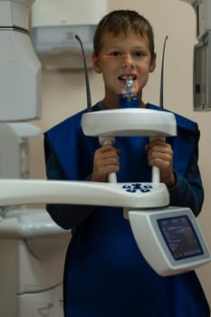 Jaw computed tomography, check up teeth in dental clinic. Little boy with open mouth on x-ray diagnostics. Circular snapshot of jaw on modern medical equipment. CT scanning, stomatology and radiology.